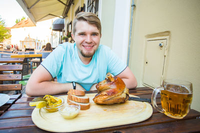 Portrait of smiling young man sitting at table