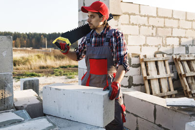 Portrait of young man standing against wall