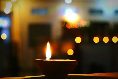 Close-up of illuminated diya in darkroom