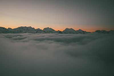 Scenic view of snowcapped mountains against sky during sunset