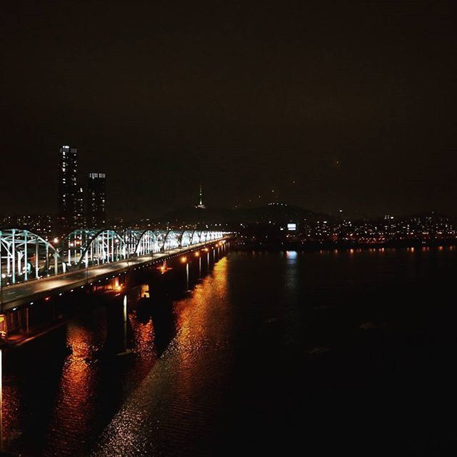 illuminated, night, architecture, built structure, water, connection, bridge - man made structure, river, city, waterfront, building exterior, reflection, bridge, transportation, copy space, clear sky, engineering, sky, street light, lighting equipment