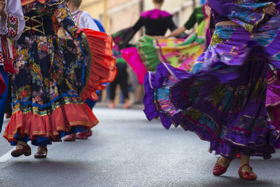 Low section of women dancing on street in city