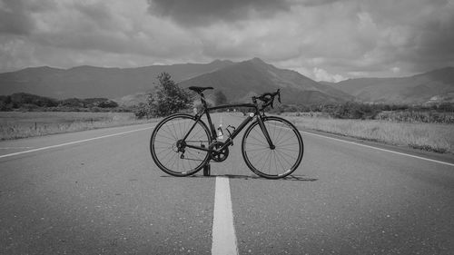 Bicycle on road against sky