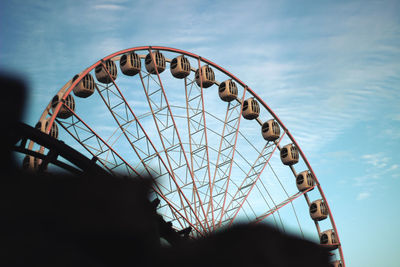 Low angle view of ferris wheel against blue sky