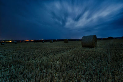 Hay bales on field against sky