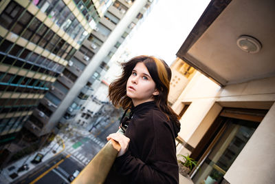 Portrait of young woman looking away in city