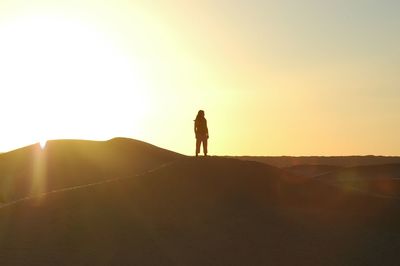 Silhouette man standing on mountain against sky during sunset