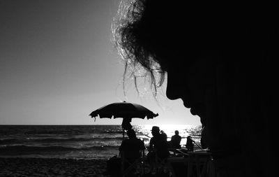 Silhouette of people on beach at sunset