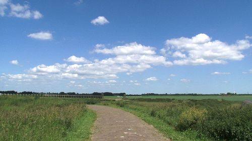 Country road against cloudy sky