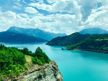 Scenic view of sea and mountains against sky