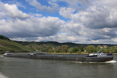 Boats moored in river against sky