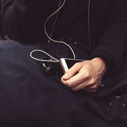 Midsection of man holding mobile phone