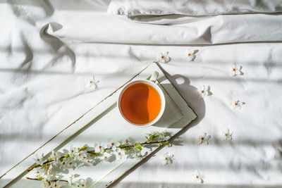 High angle view of tea cup on bed