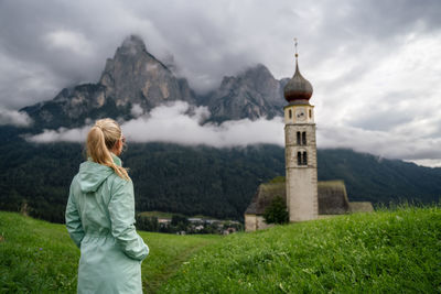 Woman standing on top of mountain against sky