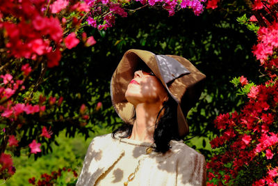 Portrait of young woman standing against plants