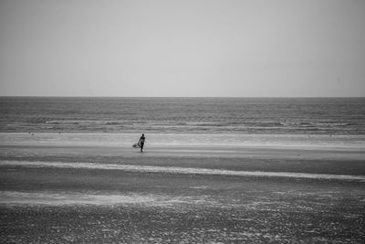 Man standing on beach against clear sky