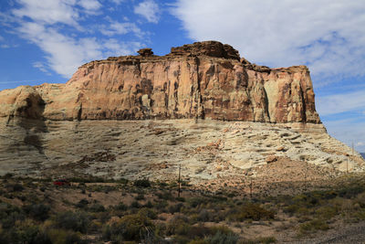 Rock formations on landscape against cloudy sky