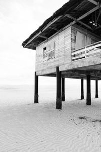 Built structure on beach by sea against sky