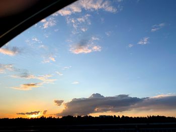 Silhouette trees on field against sky at sunset