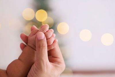 Cropped image of mother holding hands