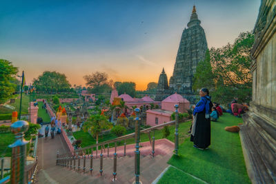 Rear view of man outside temple against building