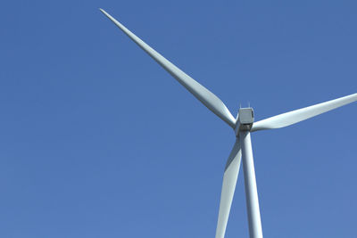 Wind turbine against clear blue sky with copy space