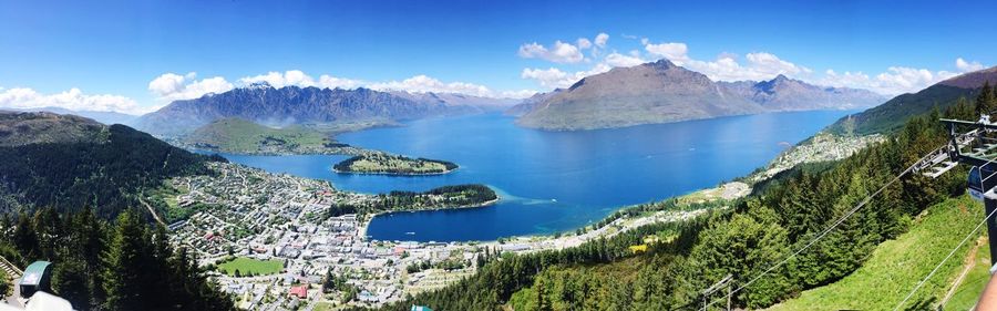 Panoramic view of sea and mountains against blue sky