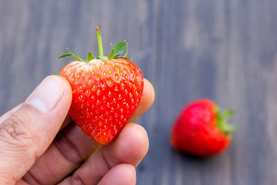 Cropped image of hand holding strawberry