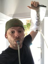 Portrait of young man holding window