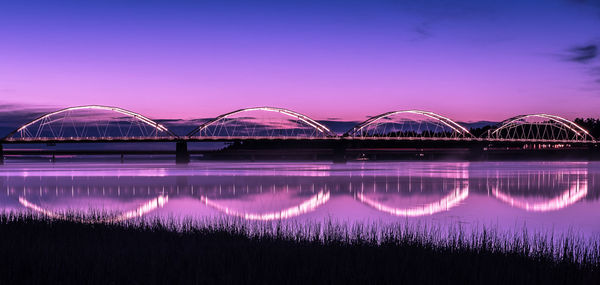 Illuminated bridge against sky at night