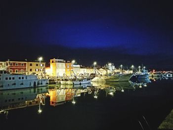 Panoramic view of illuminated harbor against sky at night