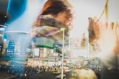 People on illuminated street in city at night