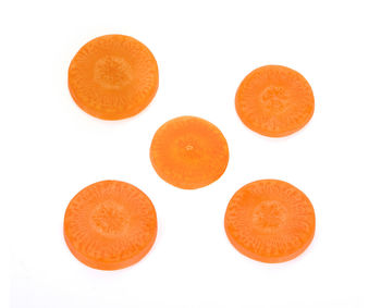 Close-up of carrot slices over white background