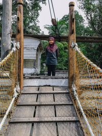 Portrait of girl standing on footbridge