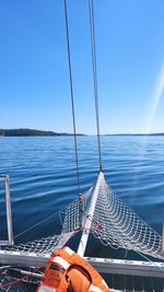 Sailboat sailing in sea against clear blue sky