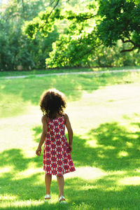 Rear view of girl running on field