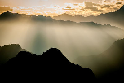 Scenic view of silhouette mountains against sky during sunset