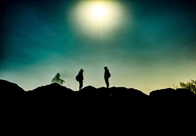 Low angle view of silhouette man standing against sky at night