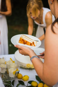 Midsection of woman holding ice cream in plate