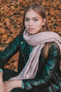 Portrait of a beautiful young woman with autumn leaves