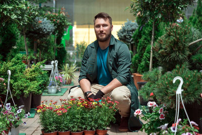 Portrait of young man standing against plants