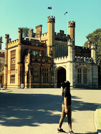 Full length of woman walking on street against buildings in city