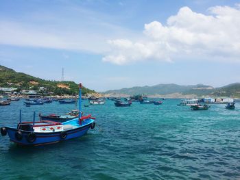 Boats moored on sea against sky