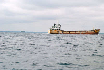 Ship sailing on sea against sky