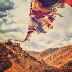 Prayer flags in mountains against cloudy sky