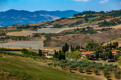 Scenic view of field and houses against mountains