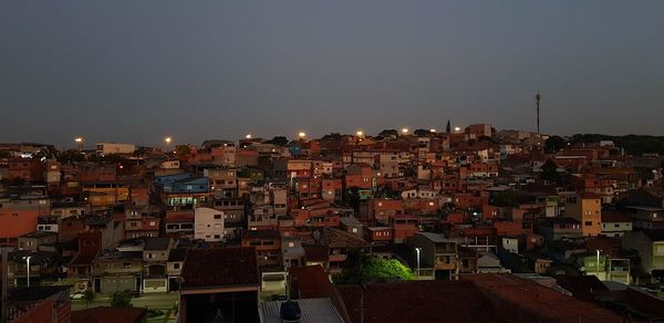 Aerial view of illuminated buildings against sky at night