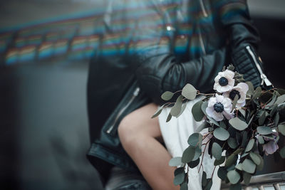 Midsection of woman holding flower bouquet