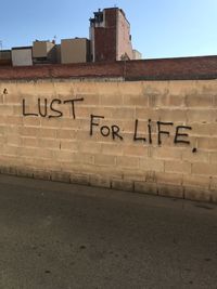 Text on wall against clear sky