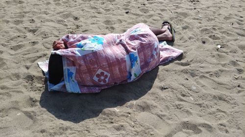 High angle view of man lying on sand